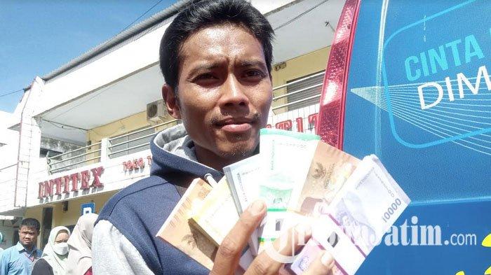 Sandra Irawan (31) menunjukkan uang baru hasil penukaran di mobil Bank Indonesia.