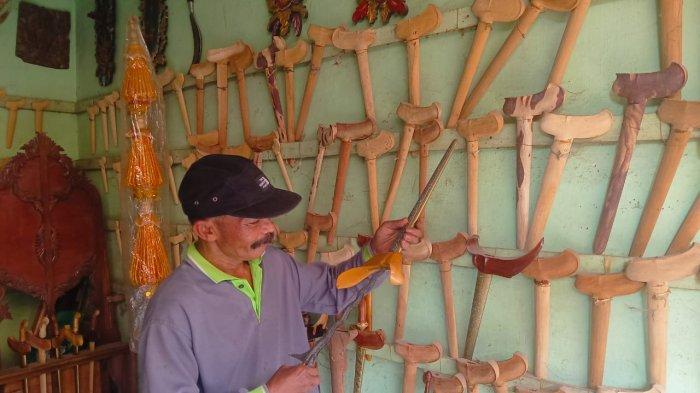 BULAN SURO JOMBANG - Sudahri (55) Pengrajin Warangka aal Desa Miagan, Kecamatan Mojoagung, Kabupaten Jombang, Jawa Timur saat Memoles Warangsa Pesanan Pembeli, Selasa (24/6/2025). Untung melimpah dari Warangka saat bulan suro.