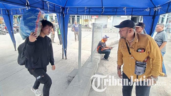 JUPANG - Seorang juru panggil (jupang) penumpang memandu calon penumpang di Terminal Arjosari Malang yang hendak naik bus, Sabtu (28/6/2025). Situasi Terminal Arjosari tampak aktif seperti biasa pasca pengeroyokan seorang anggota TNI AL.
