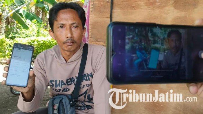 Hasanuddin (44) warga Dusun Krajan, Desa Bulu, Kecamatan Kraksaan, Kabupaten Probolinggo, tengah menunjukkan bukti transfer pembelian minyak goreng, Kamis (8/3/2023).