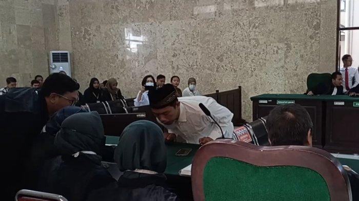 Terdakwa Dendi Atzinar Rahman berkonsultasi dengan tim penasihat hukumnya, sebelum menyatakan menerima putusan majelis hakim PN Tulungagung.