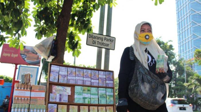 Teriknya matahari di Surabaya hari ini Jumat (30/4/21) tak menyurutkan semangat Yuli untuk sesekali bersuara menawarkan jasa tukar uang baru kepada para pengendara yang melintas di Jalan Raya Mayjen Sungkono. Bahkan, Yuli juga selalu menjalankan ibadah puasa.
