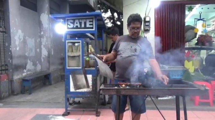 NAIK HAJI - Erfan, saat jualan sate di jalan Trunojoyo Kelurahan Kepatihan Kecamatan Kaliwates Jember, Jawa Timur, Jumat (2/5/2025) Tukang sate di Jember ini berangkat haji tahun ini.