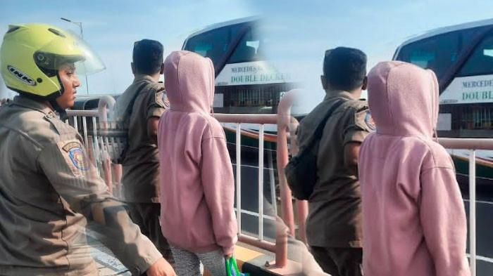 ANTISIPASI BAHAYA - Sejumlah petugas Satpol PP mengevakuasi seorang wanita berjalan sendirian di Jembatan Suramadu, Rabu (23/7). Ia menunjukkan raut muka sedih saat dievakuasi petugas.