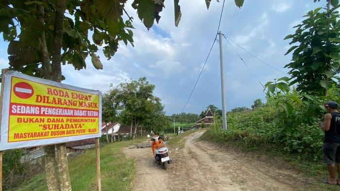 JALAN RUSAK - Seorang warga Dusun Batu Putih, Desa Kladi, Kecamatan Cermee melintas di jalan yang baru saja dirabat dengan anggaran swadaya masyarakat, pada Kamis (22/5/2025)