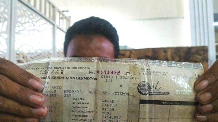 STNK TUNGGAK PAJAK - Seorang warga menunjukkan Surat Tanda Nomor  Kendaraan (STNK) miliknya mati sejak tahun 2019. Dia berharap di Jawa Timur ke depan ada kebijakan penghapusan pajak kendaraan yang sudah tertunggak.