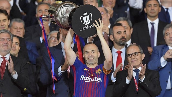 Andres Iniesta, mengangkat trofi juara Copa del Rey 2018 yang diraihnya pasca mengalahkan Sevilla 5-0 di Stadion Wanda Metropolitano, Madrid, pada Minggu (22/4/2018).