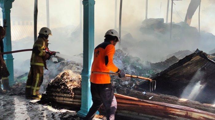 Petugas Satpol PP dan Damkar Klaten saat melakukan pendinginan area gudang yang terbakar di Gergunung, Klaten Utara, Klaten, Jawa Tengah, Rabu (9/8/2023).