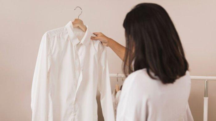 Back view woman looking at a white shirt