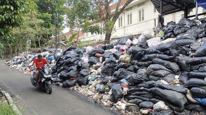 Seorang pengendara sepeda motor tampak menutup hidung saat melintasi Depo Kotabaru, Kota Yogyakarta.