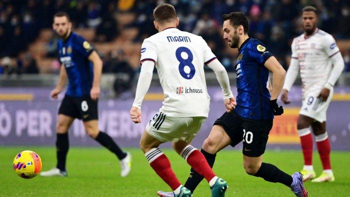 Gelandang Inter Milan asal Turki Hakan Calhanoglu (kanan) bersaing dengan bek Cagliari Razvan Marin pada pertandingan sepak bola Serie A Italia antara Inter Milan dan Cagliari di Stadion Giuseppe Meazza di Milan pada 13 Desember 2021.