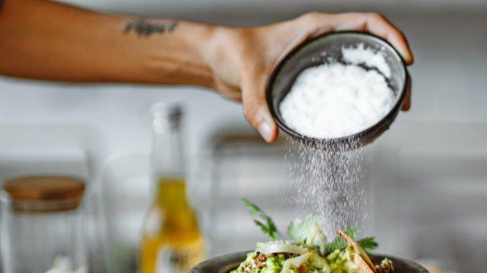Ilustrasi membumbui makanan dengan garam