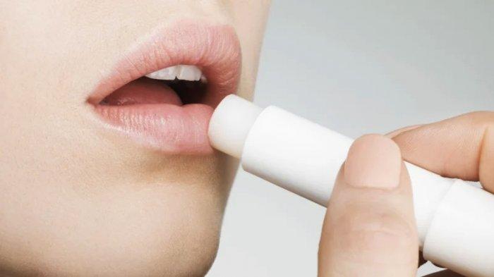 Ilustrasi seorang wanita sedang mengaplikasikan lip balm untuk melembapkan bibir