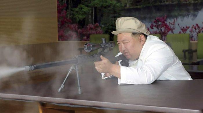 Pemimpin tertinggi Korea Utara Kim Jong Un mencoba sebuah senapan saat melakukan inspeksi tiga hari di pabrik senjata pada 3-5 Agustus 2023.