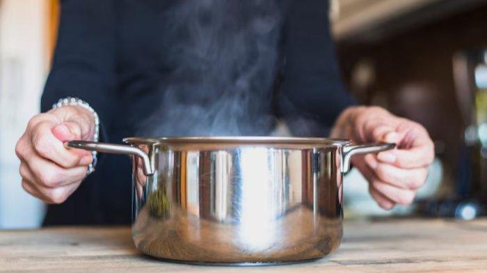 Crop hands of woman cooking dish in kitchen