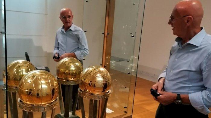 Mantan pelatih tim nasional sepak bola Italia dan dua kali manajer AC Milan, Arrigo Sacchi berpose di depan reproduksi trofi Piala Interkontinental 1989 dan 1990 pada 8 September 2021 di Museum Kota San Rocco di Fusignano, di pameran 
