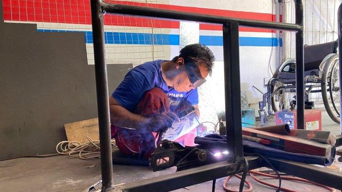 Seorang Teknisi Bengkel Sahabat Difabel yang dikelola oleh Forum Peduli Difabel Bantul sedang membuat sespan di tempat usahanya, Minggu (19/11/2023).