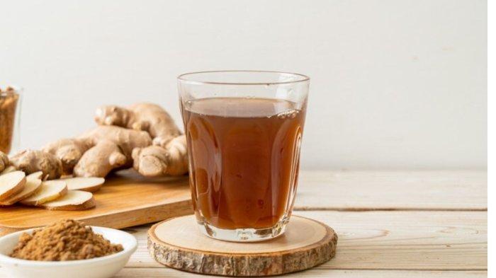 Hot and sweet ginger juice glass with ginger roots - Healthy drink style