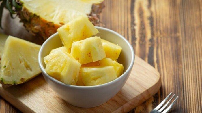 Fresh pineapple on dark wooden surface