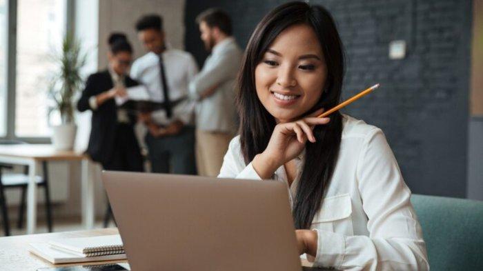 Cheerful young asian businesswoman using laptop