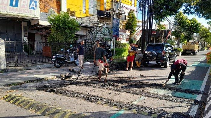 Petugas Dinas PUPR membongkar marka kejut atau polisi tidur yang dinilai terlalu tinggi di jalur lambat Jalan Pemuda, di seberang kantor Pemkab Klaten, Minggu (27/4/2025).