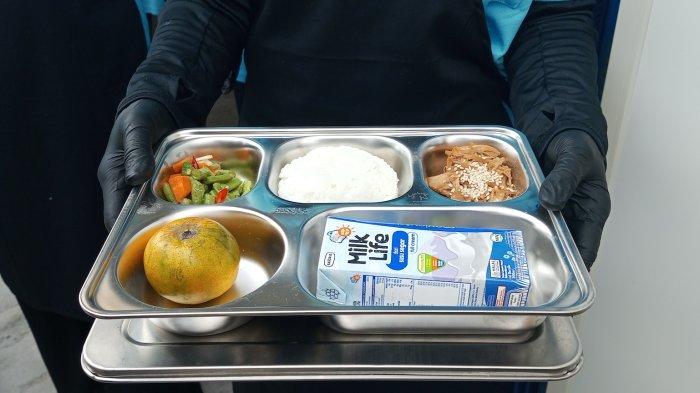Pekerja di Satuan Pelayanan Makan Bergizi menunjukkan menu yang dimasak hari ini sebagai sampel makan siang gratis buat siswa. 