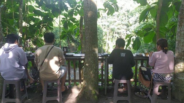 Pengunjung menikmati hidangan makanan tradisional sambil melihat aliran sungai krasak di pasar Jadoel Lembah Si Cangkring