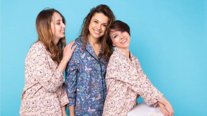 Three girls wearing colorful pajamas having fun on blue