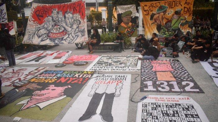 POSTER: Massa aksi penolakan UU TNI di pelataran Gedung Agung Yogyakarta membawa deretan poster berisi kalimat satir menyindir pemerintah, Kamis (27/3/2025)