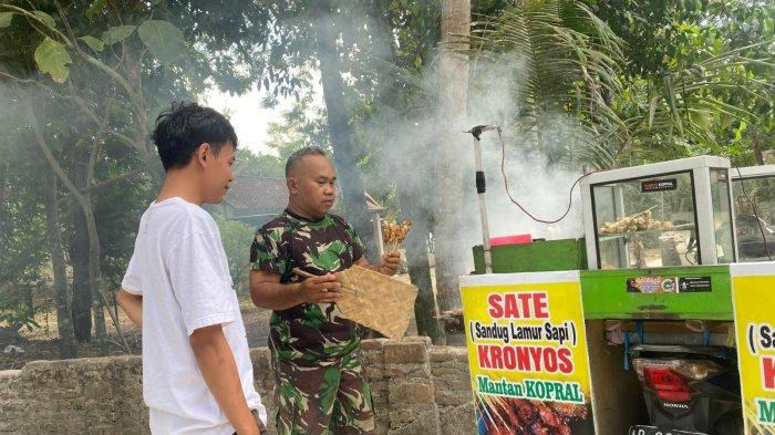 Anggota TNI dari Kodim 0730/ Gunungkidul, Sertu Sarijo, sedang nyambi jualan sate kronyos usai menjalankan tugas dinas di Padukuhan Potrobayan, Kalurahan Srihardono, Kapanewon Pundong, Kabupaten Bantul, Minggu (30/6/2024).
