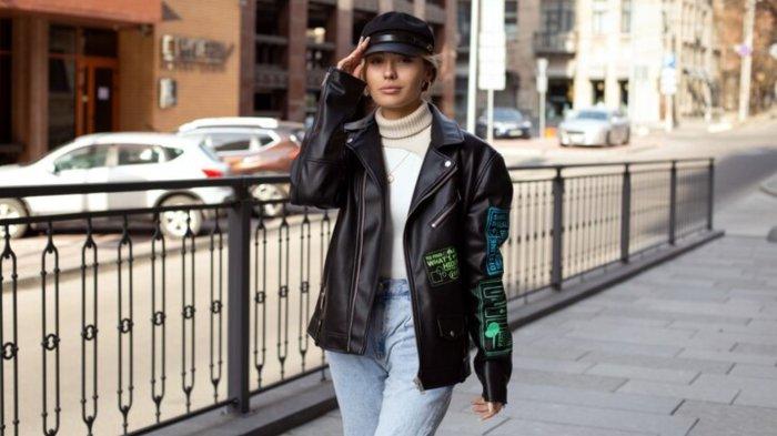 A beautiful girl in fashionable clothes and sunglasses goes shopping