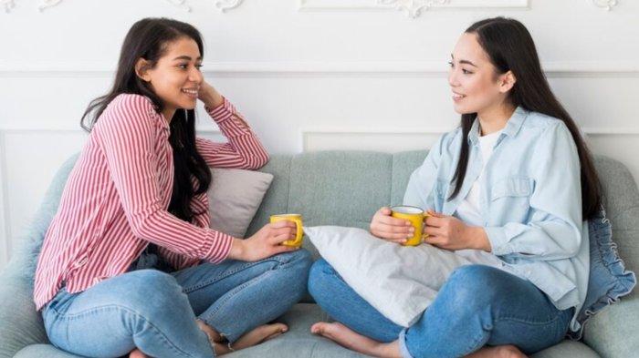 Friends chatting while sitting on sofa