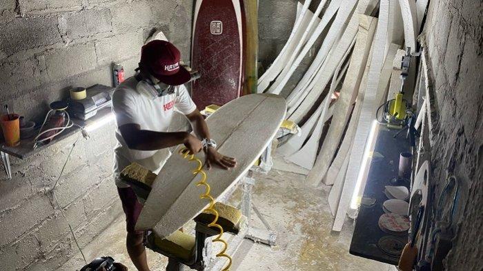PAPAN SELANCAR: Pemilik Usaha Hauw Surfboard, Bima Sepiawan (28), sedang membuat papan selancar di tempat usahanya yang berada di Mancingan 11, Kalurahan Parangtritis, Kapanewon Kretek, Kabupaten Bantul, DI Yogyakarta, Selasa (25/2/2025) siang.
