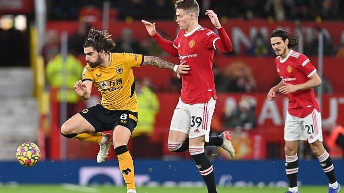 Gelandang Wolverhampton Wanderers asal Portugal Ruben Neves (kiri) bersaing dengan gelandang Manchester United Skotlandia Scott McTominay (tengah) selama pertandingan sepak bola Liga Premier Inggris antara Manchester United dan Wolverhampton Wanderers di Old Trafford di Manchester, barat laut Inggris, pada 3 Januari 2022.