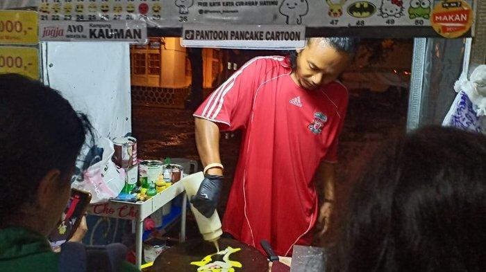 Tulus Wicaksono, penjual pancake kartun viral sedang membuatkan pesanan pembeli di plataran Masjid Kauman Yogyakarta, Sabtu (28/12/2024).