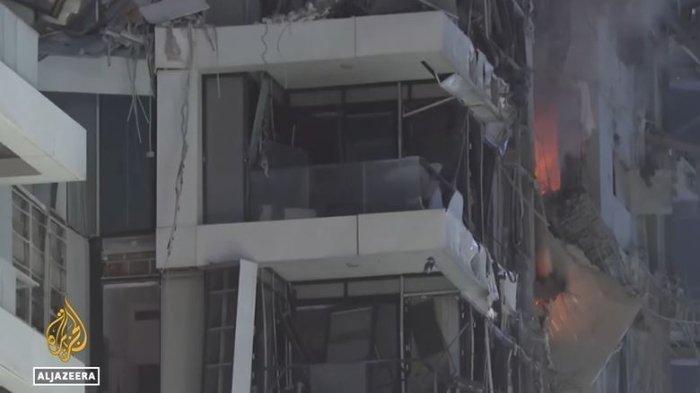 GEDUNG HANCUR - Tangkapan layar YouTube Al Jazeera English pada Sabtu (14/6/2025) yang menampilkan Sebuah gedung di Tel Aviv hangus terbakar terkena rentetan rudal Iran. Layanan medis darurat Israel, Magen David Atom mengonfirmasi bahwa seorang warga Israel kedua meninggal dunia setelah sebuah rudal langsung menghantam sebuah gedung di pusat kota Tel Aviv pada Sabtu (14/6/2025).