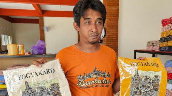 Sudarminto (41), seorang produsen kaos oblong Borobudur menunjukkan kaos produksinya