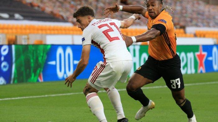 Gelandang Spanyol Wolverhampton Wanderers Adama Traore (kanan) bersaing dengan bek Yunani Olympiakos, Konstantinos Tsimikas selama putaran 16 pertandingan leg kedua UEFA Europa League antara Wolverhampton Wanderers dan Olympiakos di stadion Molineux di Wolverhampton, Inggris tengah pada 6 Agustus 2020.