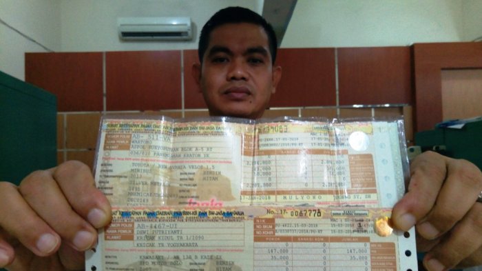 Iptu Wartono saat menunjukkan bukti bahwa biaya pengesahan STNK tahunan sekarang Rp 0. Nampak pula perbedaan signifikan antar dua STNK tersebut, Kamis (15/3/2018).