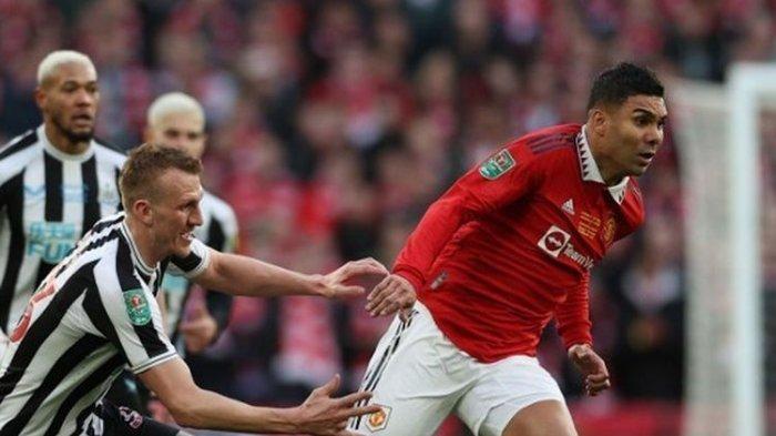 Gelandang Manchester United asal Brasil, Casemiro (kanan), coba melewati penjagaan pemain Newcastle United, Dan Burn. Laga Man United Vs Newcastle pada final Piala Liga Inggris 2022-2023 tersebut digelar di Stadion Wembley, Minggu (26/2/2023) malam WIB.(AFP/ADRIAN DENNIS)