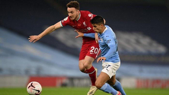 Striker Portugal Liverpool Diogo Jota (kiri) memperebutkan bola melawan bek Portugis Manchester City Joao Cancelo (kanan) selama pertandingan sepak bola Liga Utama Inggris antara Manchester City dan Liverpool di Stadion Etihad di Manchester, barat laut Inggris, pada 8 November 2020 .