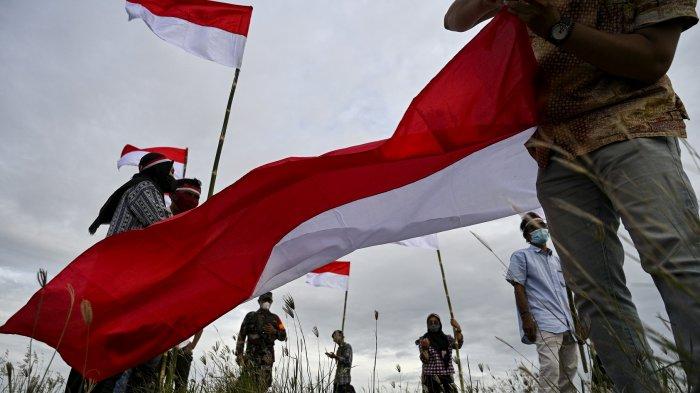Pemuda membawa bendera Indonesia untuk memperingati Hari Kemerdekaan Indonesia ke-76 yang jatuh pada 17 Agustus di Banda Aceh 16 Agustus 2021