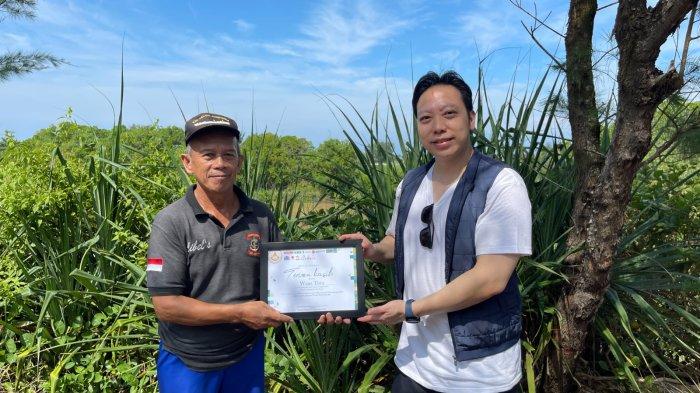 KENANG-KENANGAN : Henky Sampatti Huang (kanan), Ketua Panitia Festival Waisak Jogja saat memberikan kenang-kenangan kepada pengurus hutan bakau Wana Tirta, Kulon Progo, Minggu pagi (25/5/2025). 