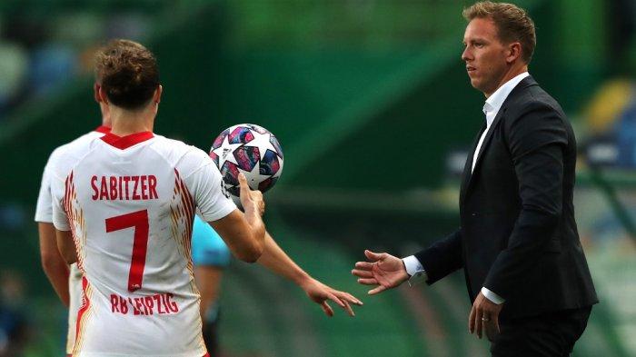 Pelatih Leipzig Julian Nagelsmann memberikan bola kepada gelandang Austria Marcel Sabitzer selama pertandingan sepak bola perempat final Liga Champions UEFA antara Leipzig dan Atletico Madrid di stadion Jose Alvalade di Lisbon pada 13 Agustus 2020.