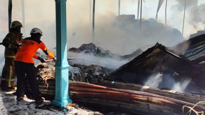 Petugas Satpol PP dan Damkar Klaten saat melakukan pendinginan area gudang yang terbakar di Gergunung, Klaten Utara, Klaten, Jawa Tengah, Rabu (9/8/2023).