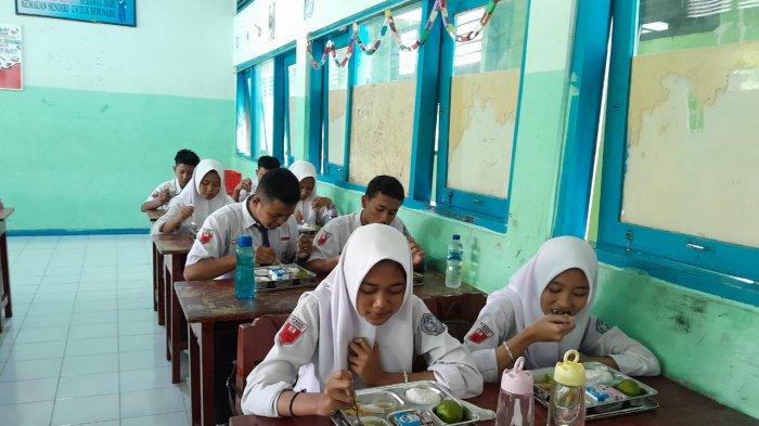 MENIKMATI MAKANAN: Siswa SMP Negeri 1 Juwiring sedang menikmati menu makanan program makan bergizi gratis (MBG) pada Senin (19/5/2025).