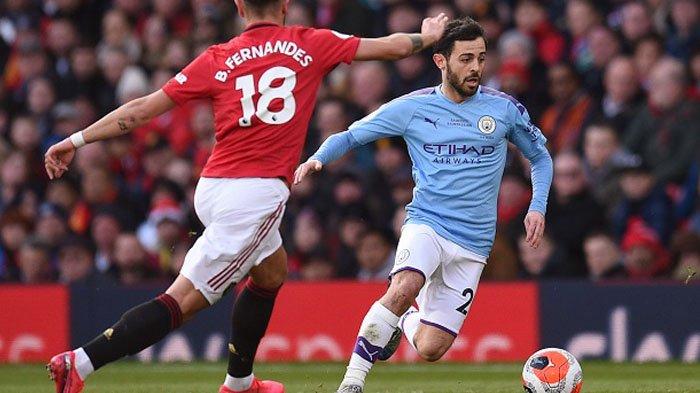 Gelandang Manchester United, Bruno Fernandes (kiri) bersaing untuk mendapatkan bola dengan pemain tengah Manchester CityBernardo Silva pada lagaManchester United dan Manchester City di Old Trafford di Manchester, 8 Maret 2020.