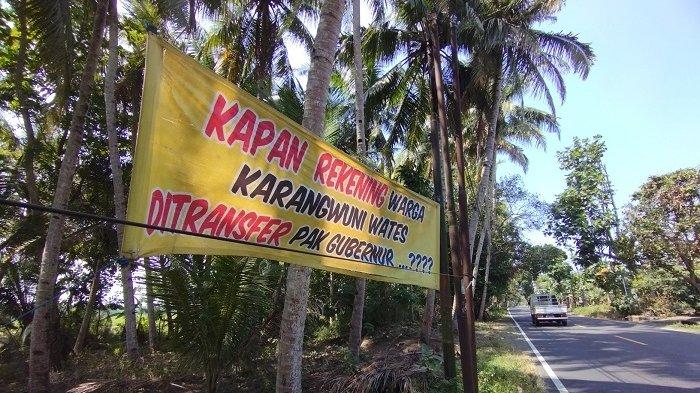 PROTES WARGA: Spanduk berisi protes dari warga Kalurahan Karangwuni, Kapanewon Wates, Kulon Progo, di tepi Jalur Jalan Lintas Selatan (JJLS), Jumat (25/07/2025). Protes berkaitan dengan tidak jelasnya pencairan Uang Ganti Rugi (UGR) proyek JJLS.