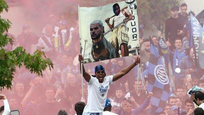 Aksi Denzel Dumfries membentangkan spanduk sindiran untuk fullback AC Milan, Theo Hernandez, dalam parade perayaan Scudetto Inter Milan, Minggu (28/4/2024). (Twitter / @F_Nerazzurra)