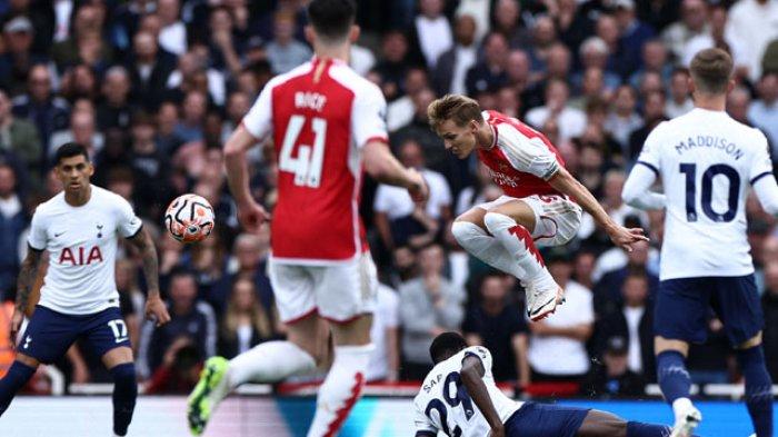 Aksi gelandang Arsenal, Martin Odegaard melewati penjagaan para pemain Tottenham Hotspur pada pertandingan pekan ke-6 Liga Inggris di Stadion Emirates, Minggu (24/9/2023).